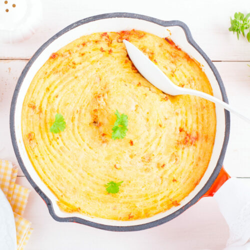 Potato casserole with meat stuffing in a frying pan, top view, horizontal